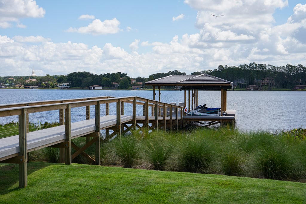 walkway leading to a covered boat dock with a boat and personal watercraft - prep a boat dock for storms